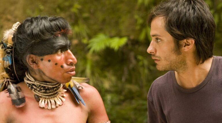A Spanish man and an indigenous Bolivian man look one another in the eyes. 