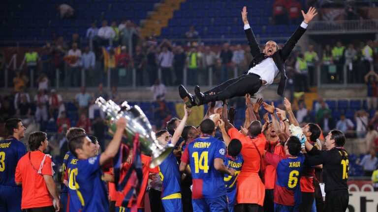 Photograph of Barcelona Football Club team members throuwing their manager, Pep Guardiola, into the air in celebration.