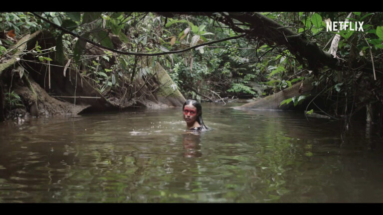 Image of a woman bathing in a pool surrounded by jungle.