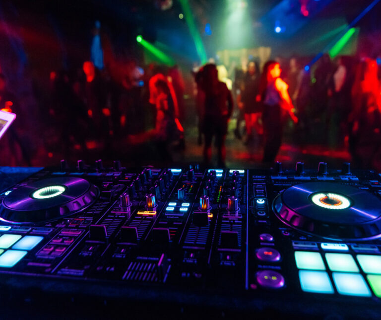 DJ console with dance floor in background.