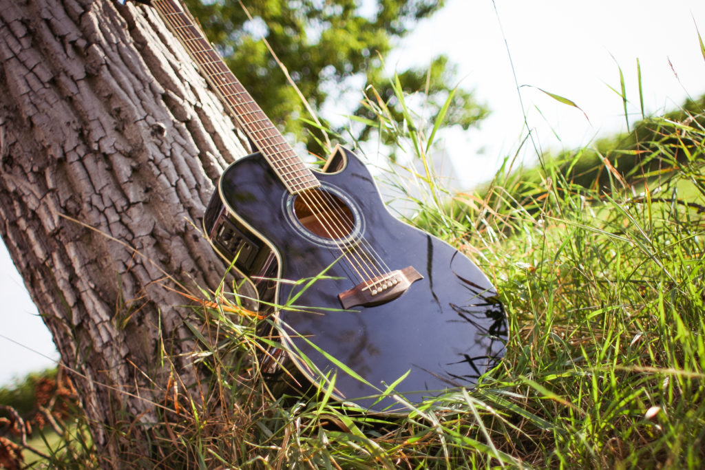 how to learn English with music guitar learning against tree trunk