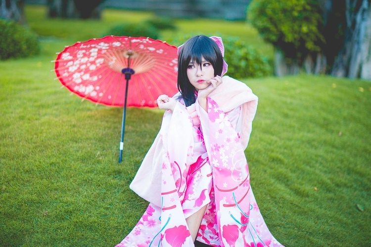 Woman wearing a traditional Japanese pink dress and parasol.