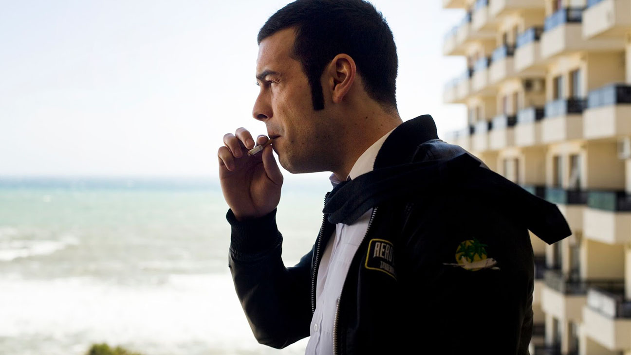 Spanish movies on Netflix: poster for Toro. Side profile of a man looking out to sea while smoking a cigarette.