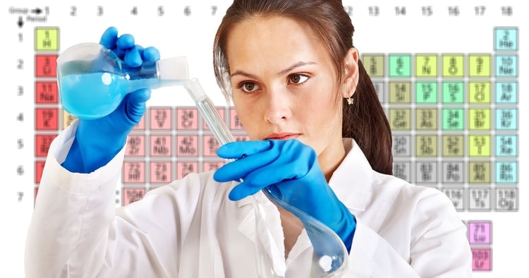 best age to learn a second language chemist measuring into a beaker wearing gloves with periodic table behind her