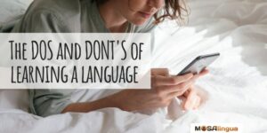 woman lying on bed looking at phone text reads "the dos and don'ts of learning a language mosalingua"