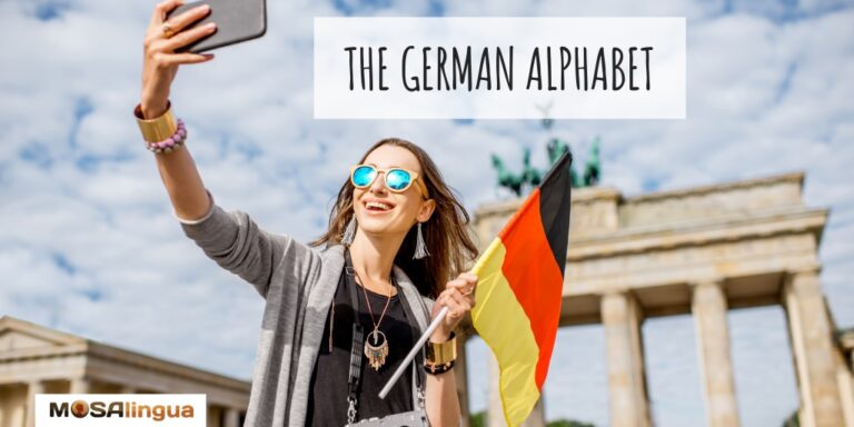 Woman holding a German flag and taking a selfie in front of the Brandenburg Gate in Berlin. The German alphabet. MosaLingua.