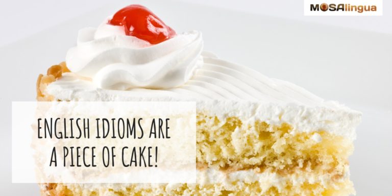 Slice of yellow cake with white frosting and a cherry on top. Text reads: Common English idioms are a piece of cake! MosaLingua