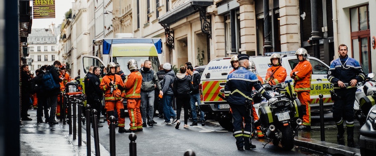 A crowd of French police officers and firefighters in the street.