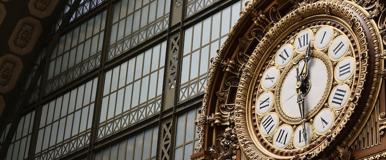 A gilded clock in the Musée d'Orsay in Paris with Roman numerals.