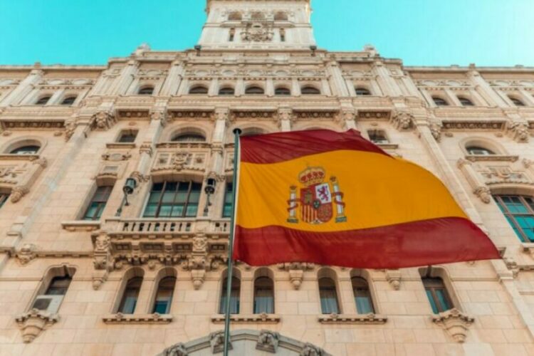 Image of the Spanish flag in front of a building.
